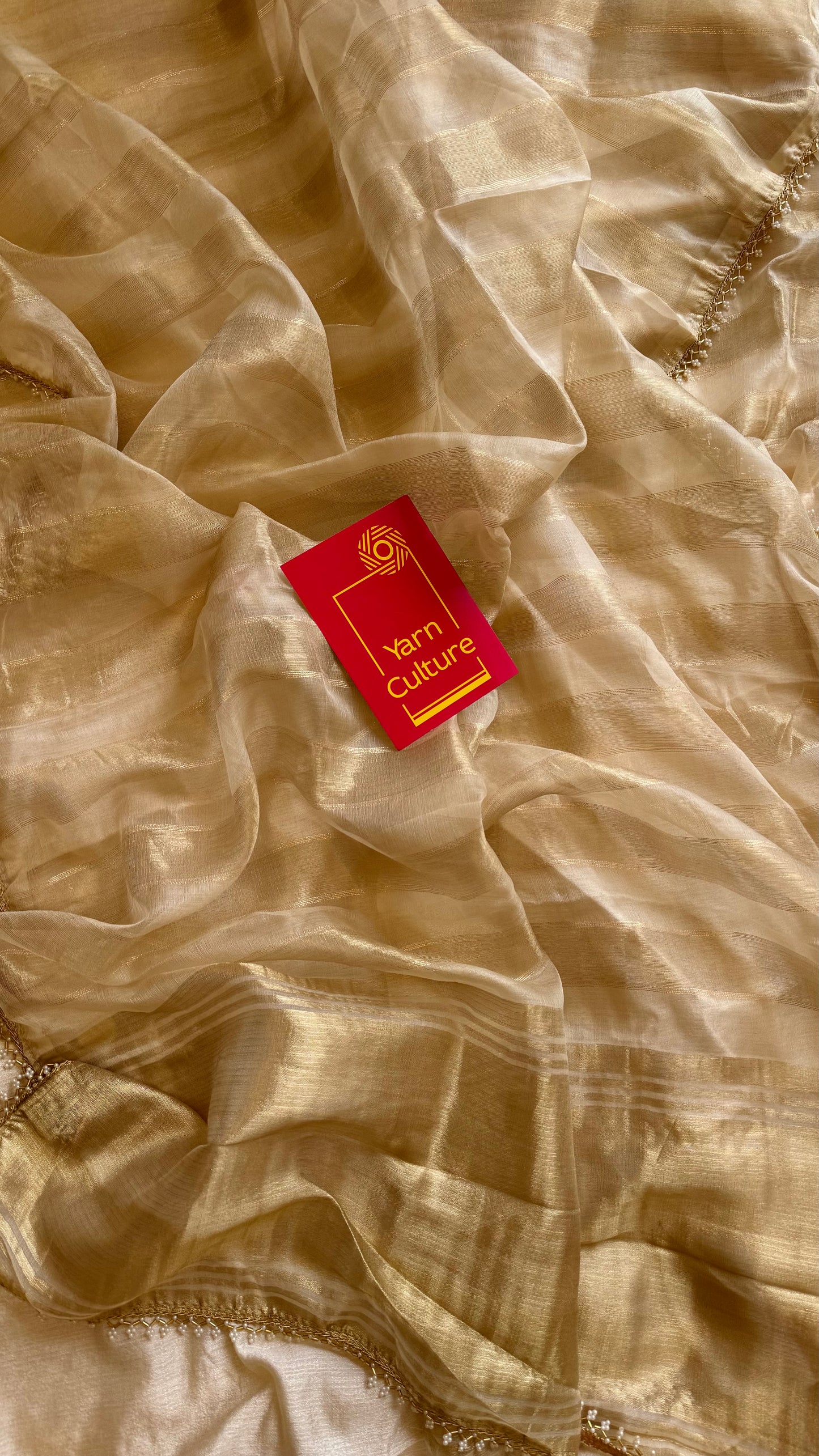 Gold soft semi tissue saree, striped body, pearl embellished border - YCIEON83