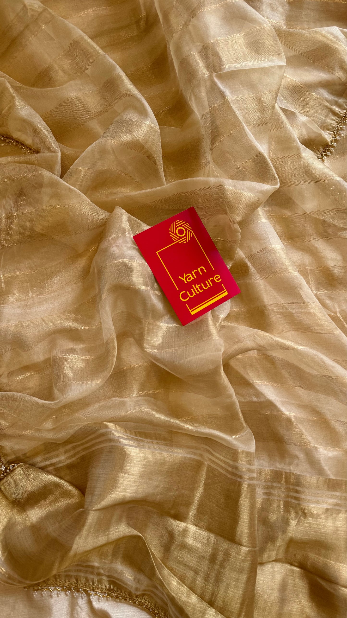 Gold soft semi tissue saree, striped body, pearl embellished border - YCIEON83