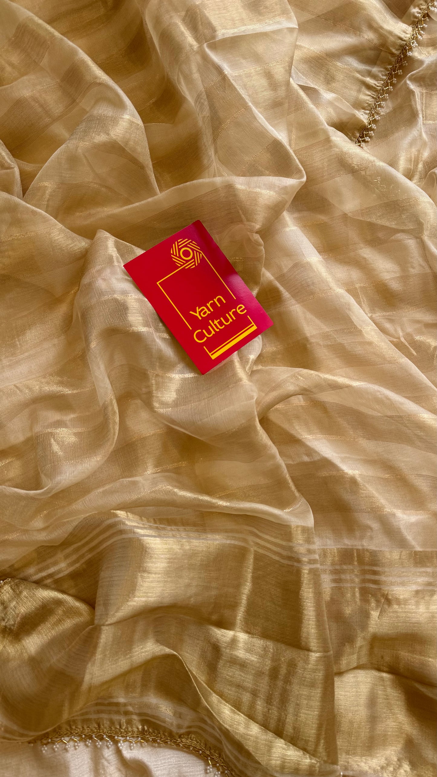 Gold soft semi tissue saree, striped body, pearl embellished border - YCIEON83