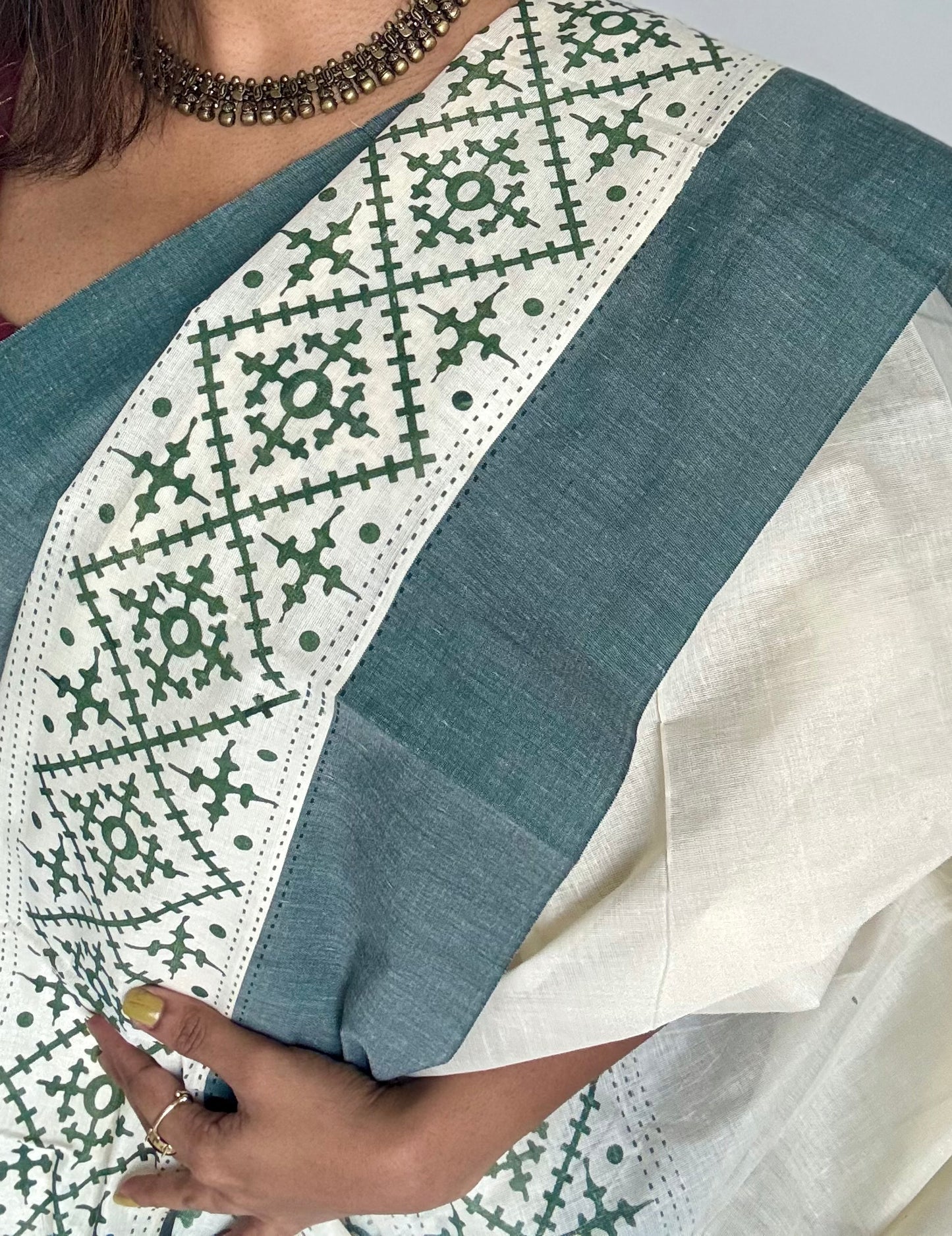 Ivory Kerala cotton saree with green Kutch-inspired printed borders and green centre pleats - YCIEKCFE314