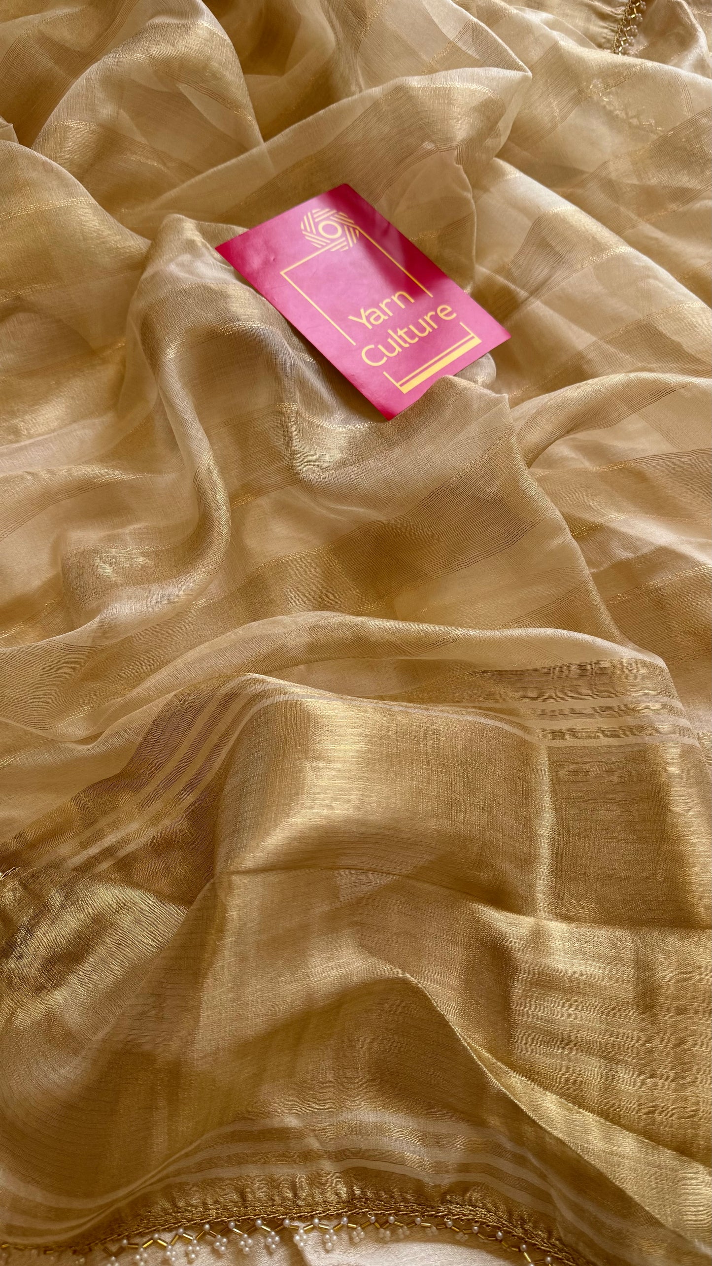 Gold soft semi tissue saree, striped body, pearl embellished border - YCIEON83
